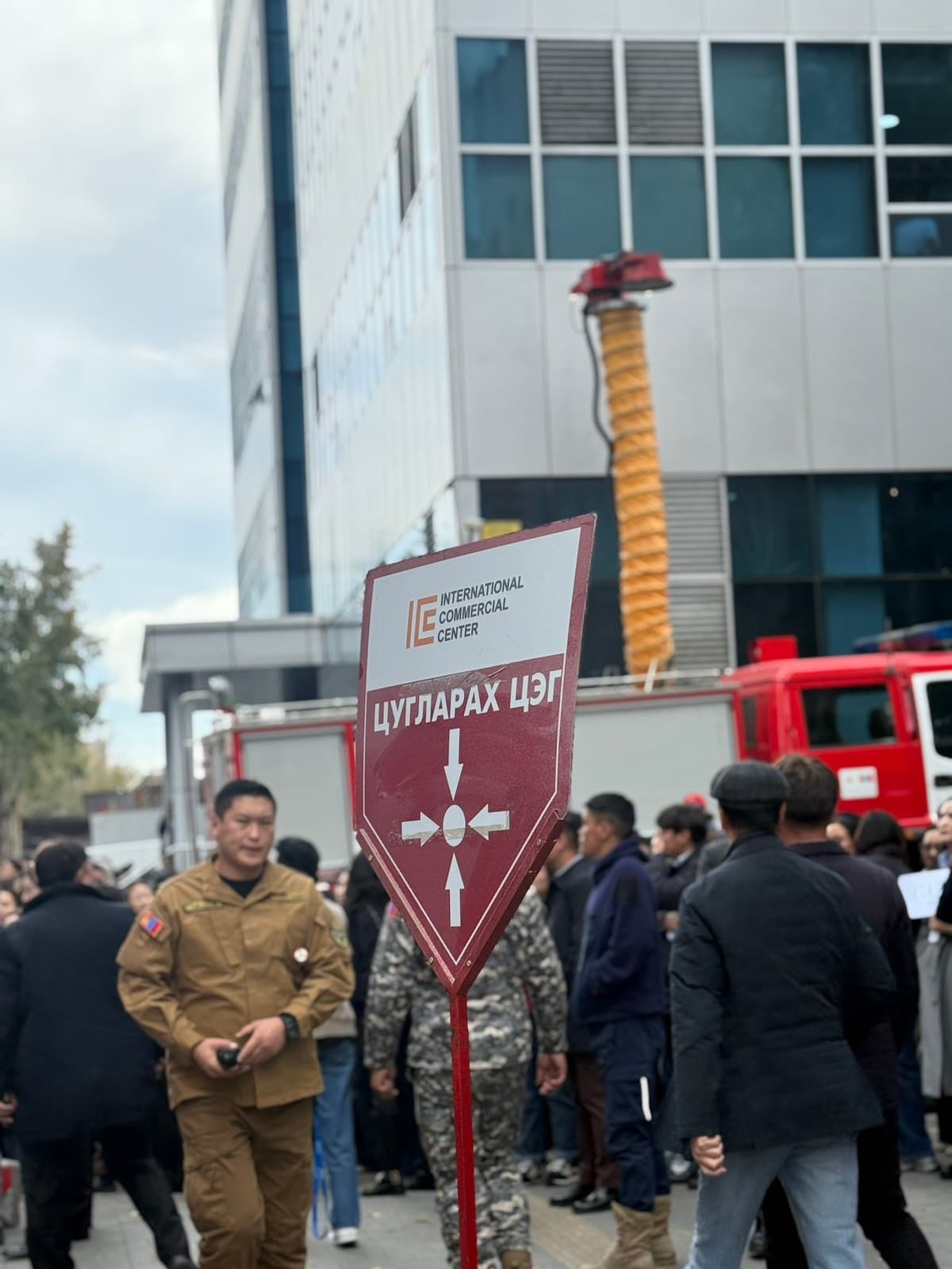 Evacuated staff at the assembly point sign, with a fire engine behind