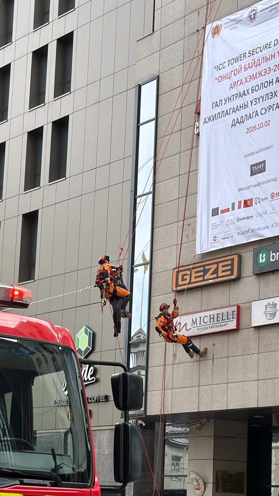 Rescuers rappelling down the ICC Tower facade
