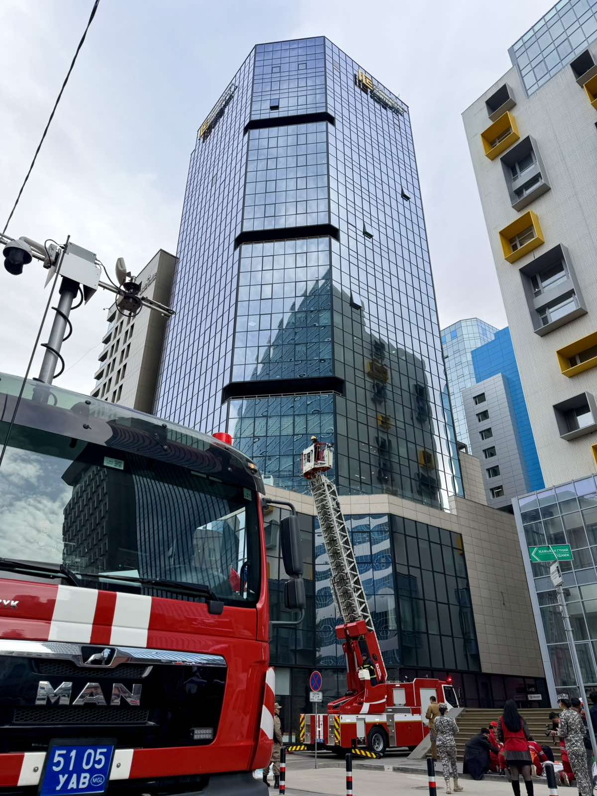 A fire engine with its aerial ladder raised beside ICC Tower